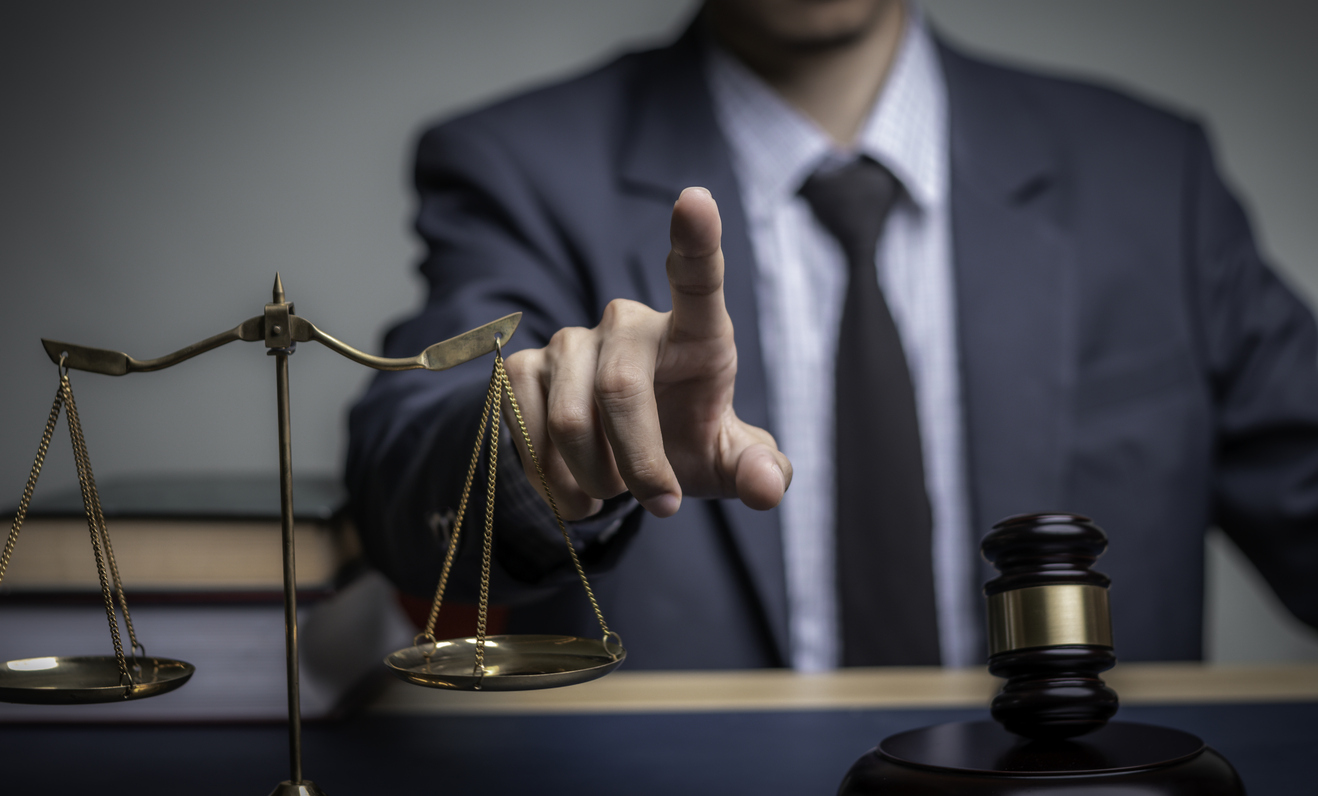 Attorney with scales of justice and gavel, emphasizing the importance of preventive legal counsel over reactive litigation for businesses and individuals.