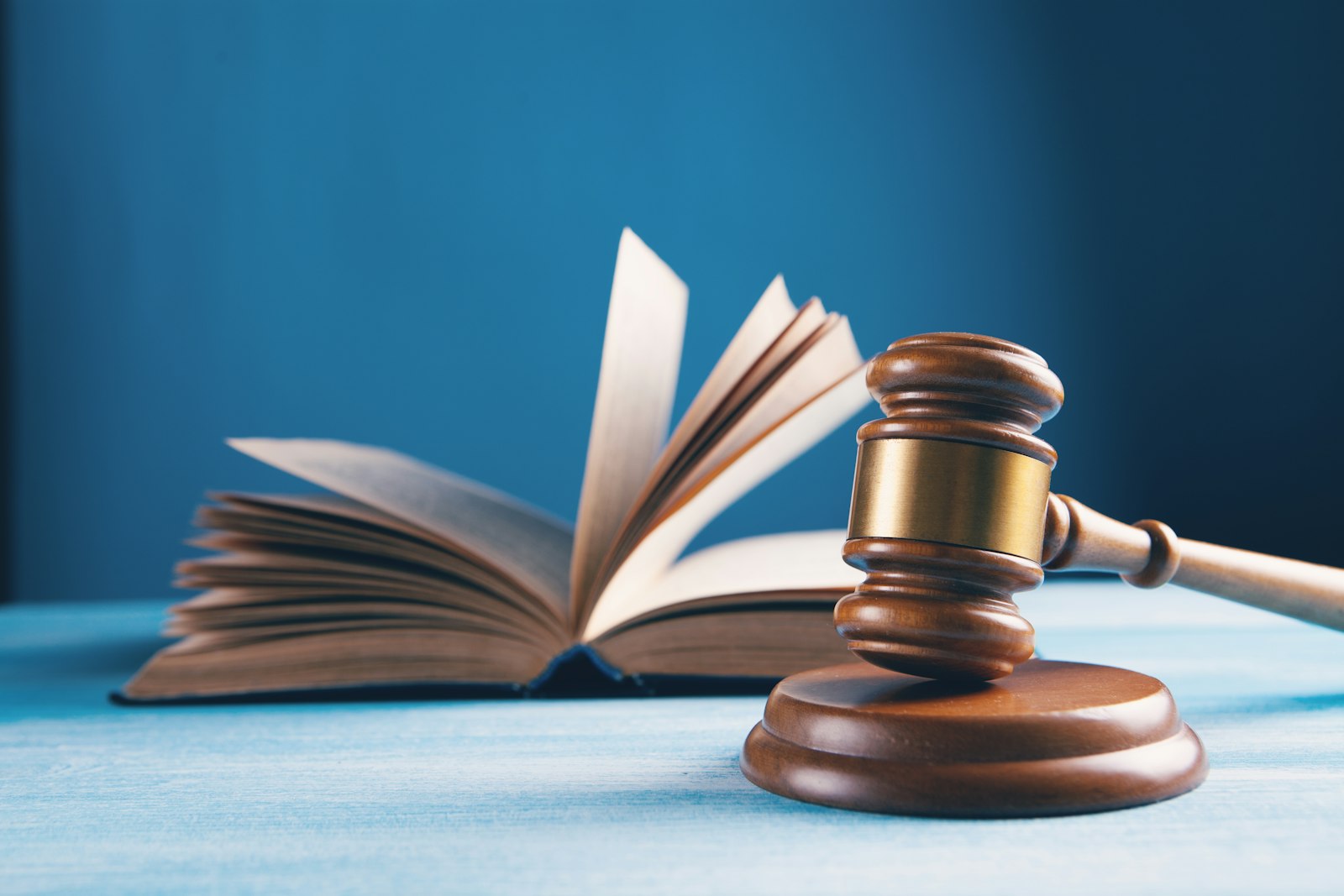 Wooden gavel and open law book representing breach of contract laws in California