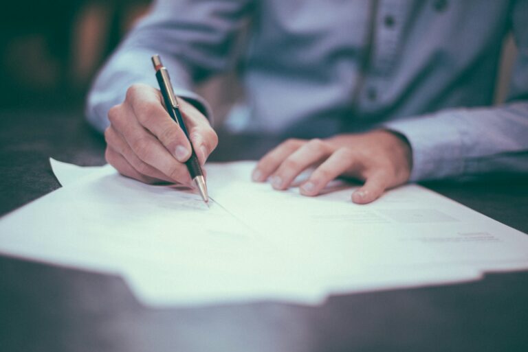 Person signing a legally binding business contract in California